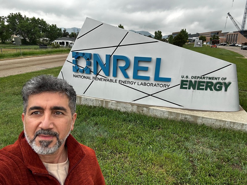 Dia taking a selfie with the NREL entry sign to their site behind