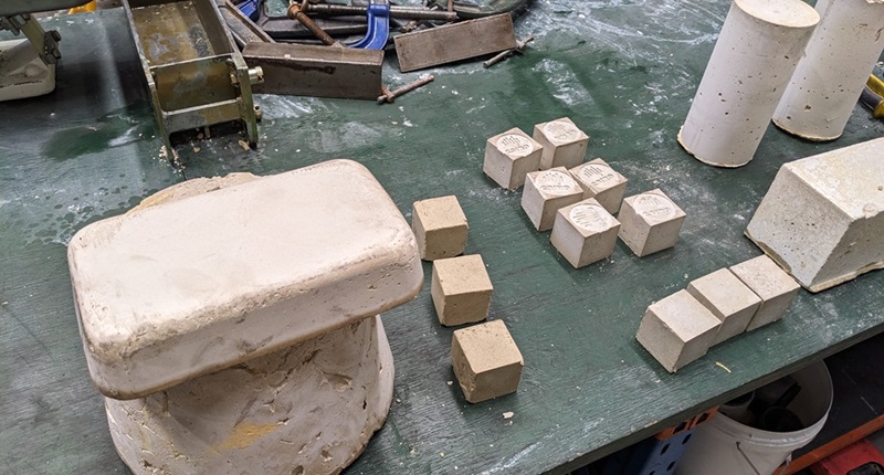 Geopolymer clay and blocks on work bench