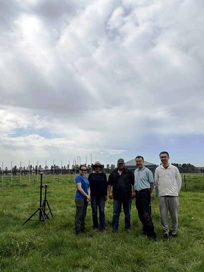 Five people in a field with grass.