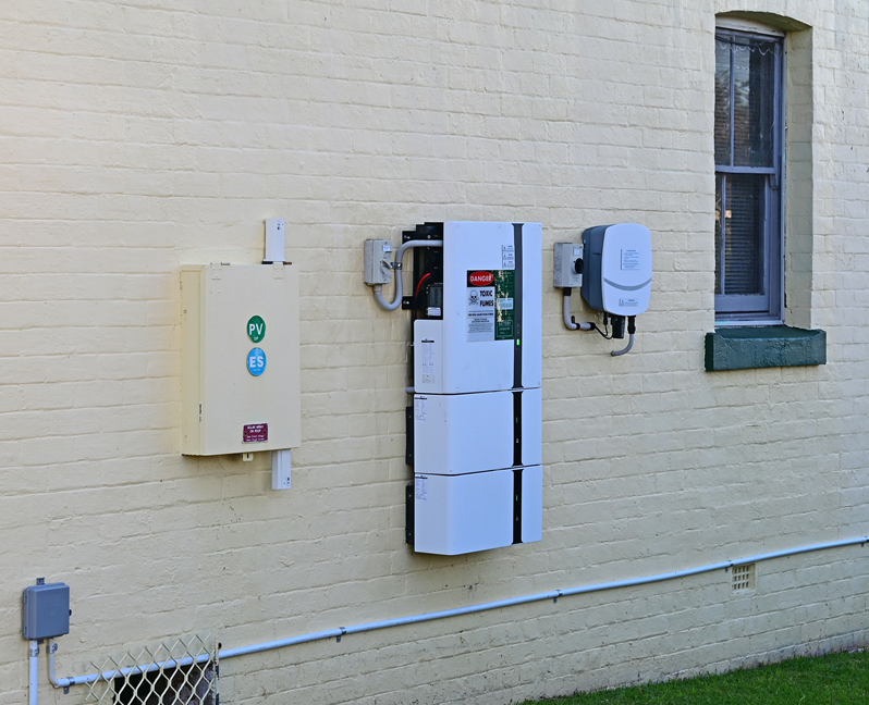 Solar home battery and inverter on the side of a house.