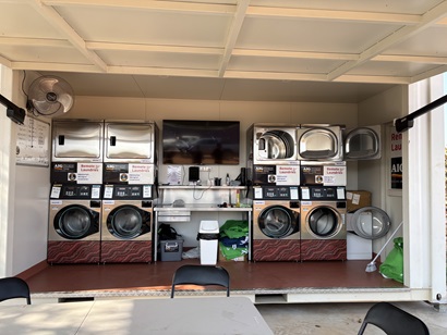 View inside the portable remote laundries with a bank of washing machines and dryers.