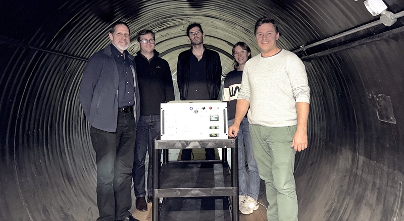 CSIRO researchers in a tunnel with a trolley and on top of the trolley is a Quantum Light Sources machine