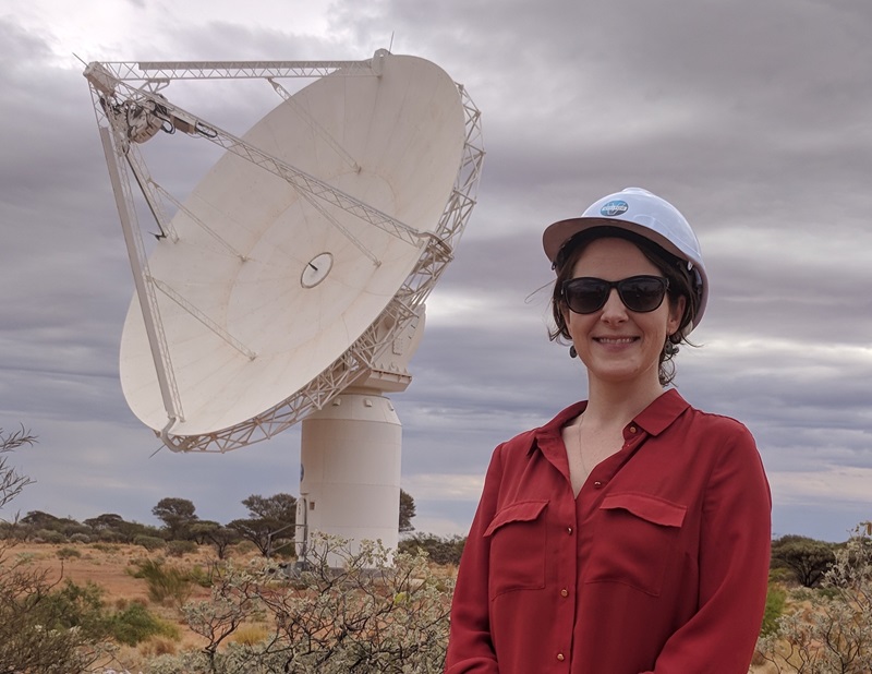 Elizabeth Mahony, a CSIRO research scientist and one of the leaders of the FLASH survey in a hard hat in front of an antenna