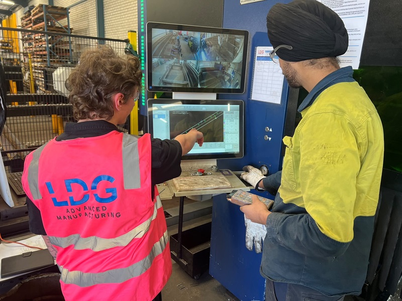 Lucas (left) talking to laser machine operator (right) about a job he was coordinating/managing.
