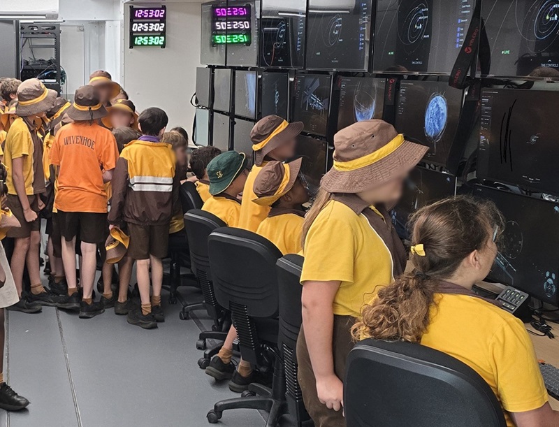 Primary school students gather around monitors aboard CSIRO's space truck