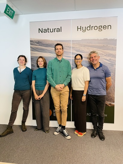 A group of five people standing infront of board that reads 