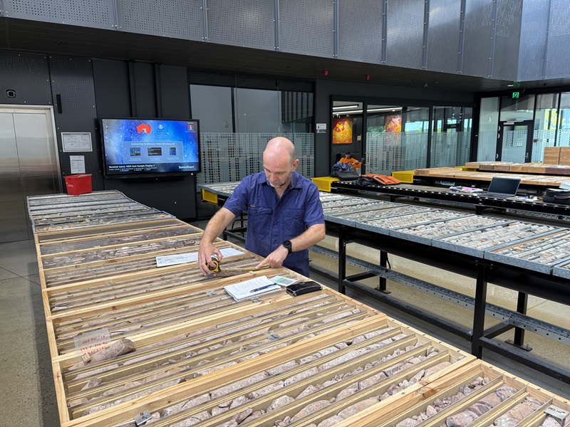 Man wearing blue shirt. He is working with ground test samples that were extracted for purposes of hydrogen extraction testing.