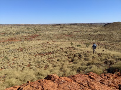 A red rocky desert landscape viewed from the top of a rocky outcrop.