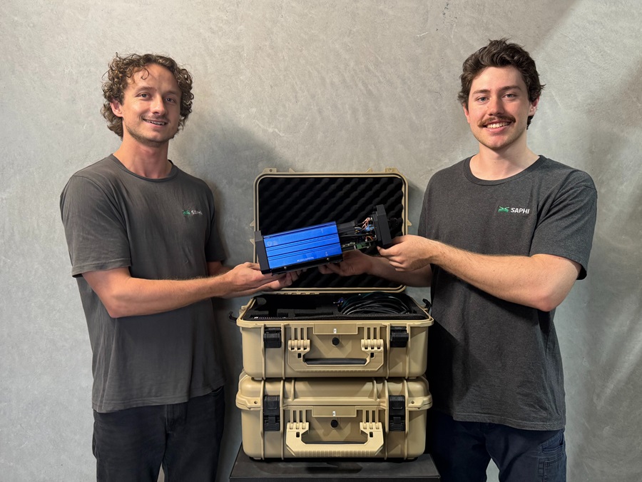 Two male tertiary-level students standing side by side infront of a stacked carry case