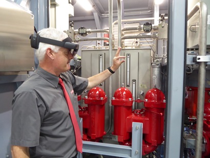 A HYDAC employee wearing a HoloLens headset and interacting with virtual equipment.