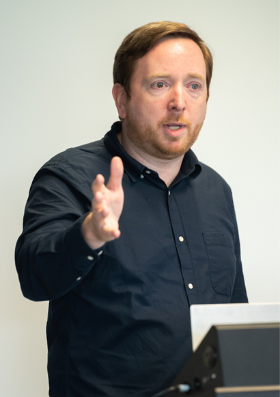 Gary Delaney talking at a lecturn.