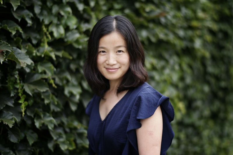 A headshot of Dr Maisie Li in front of a green hedge