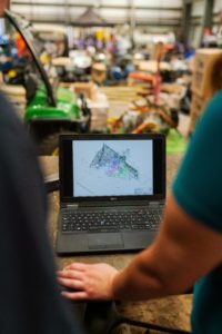 People using a laptop to automate development in a factory