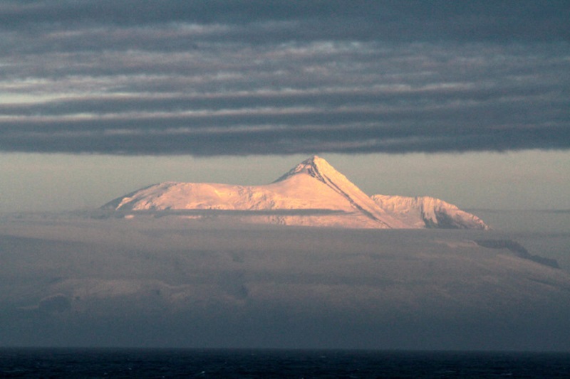 An ocean island surrounded by cloud.