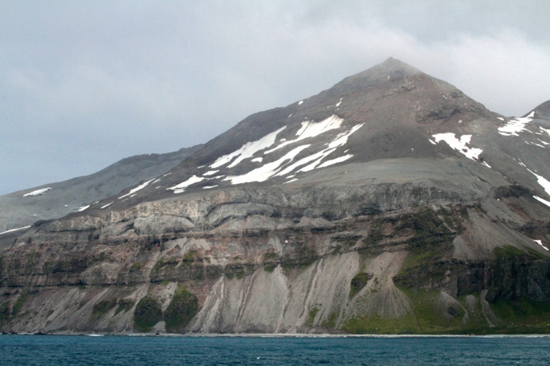 Layers of rock along the coastline of a remote oceanic island.