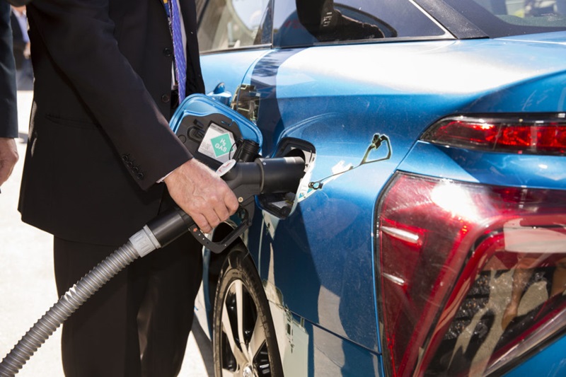 Man filling a hydrogen car with fuel