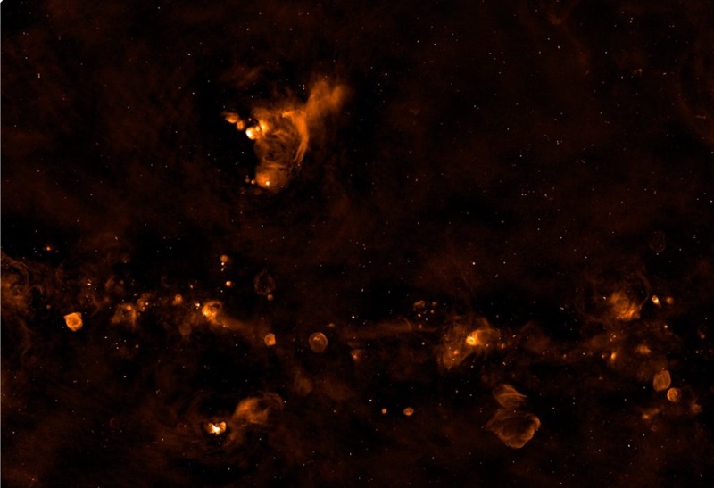 Top 10 images from ASKAP. Odd-shaped orange bubbles and whispy forms align left to right along a dark sky. 