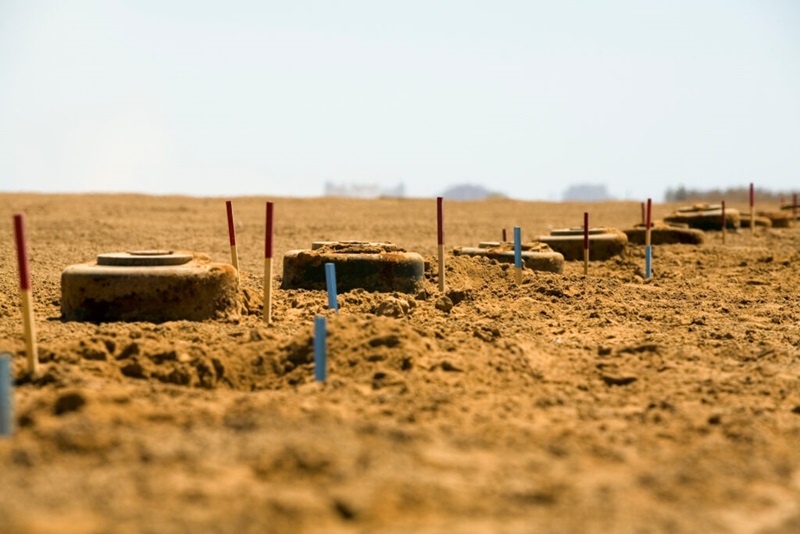A photo showing a dry landscape with landmines on the earth floor