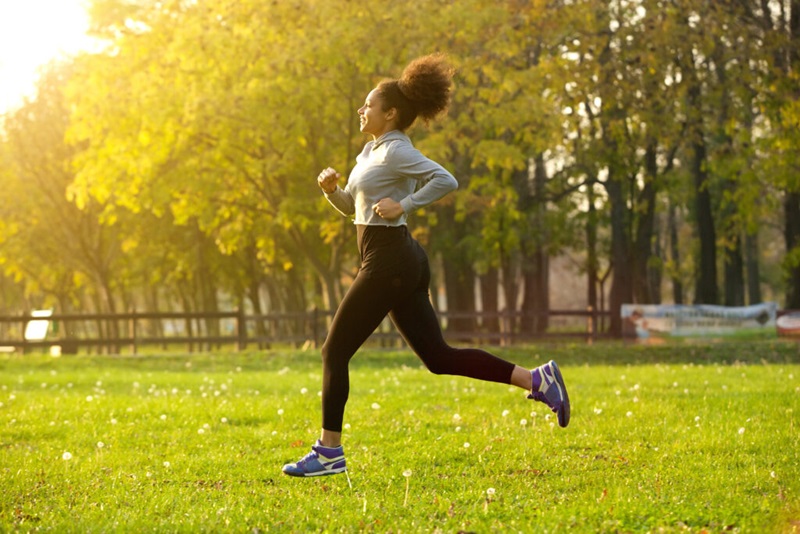 Side view portrait of a young woman running outdoors