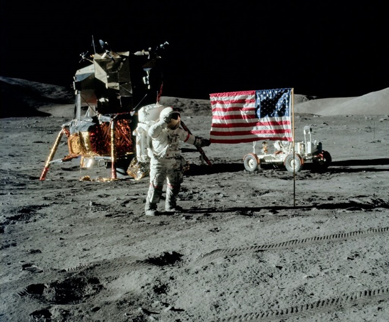 Astronaut on the moon holding the American flag.
