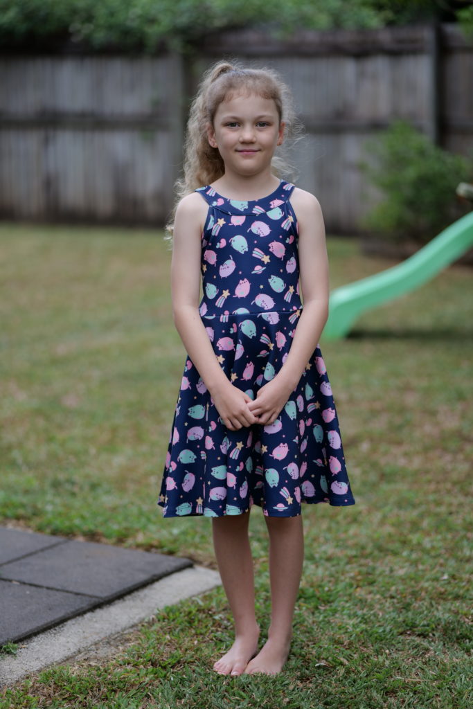 Girl standing in the garden smiling at the camera. </p><p>