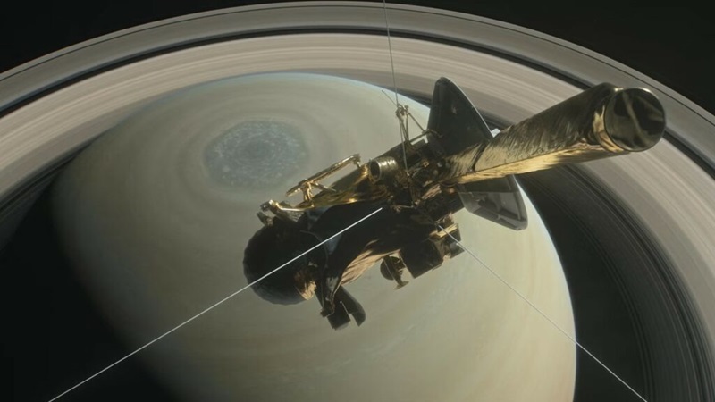 Illustration of a gold spacecraft headed towards planet with rings.