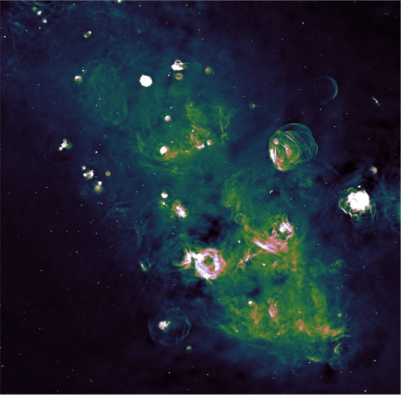 Image of the night sky, showing part of the galactic plane taken through the ASKAP radio telescope and the Parkes radio telescope, appearing as multiple coloured gaseous looking clouds on a dark black/blue background