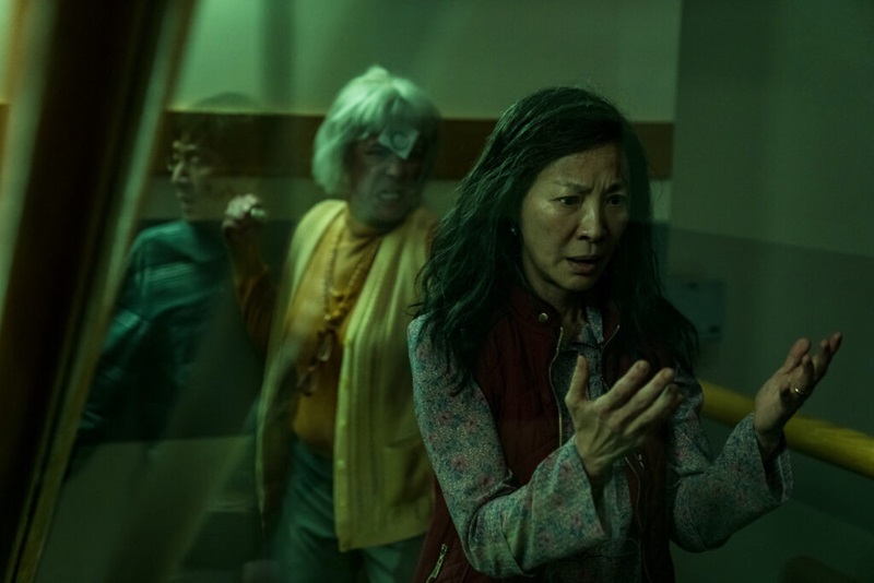 Character of Evelyn (played by Michelle Yeoh) in the film Everything Everywhere All at Once looking at her hands