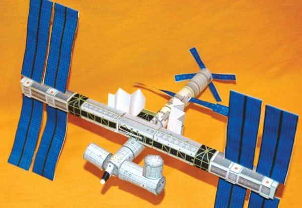 paper model of the international space station on a yellow background