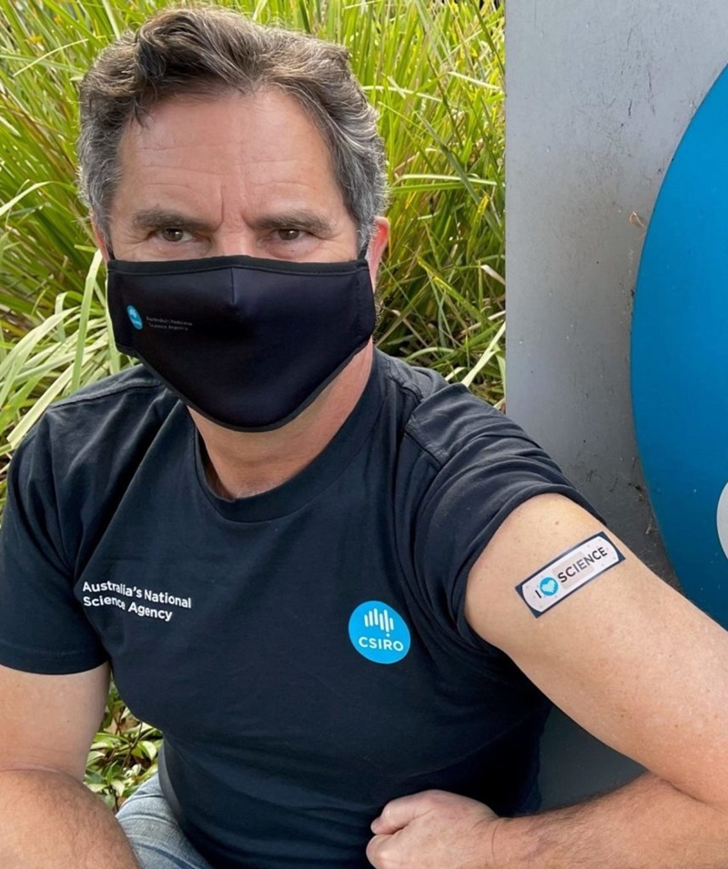 Man shows his arm and band-aid after vaccination.