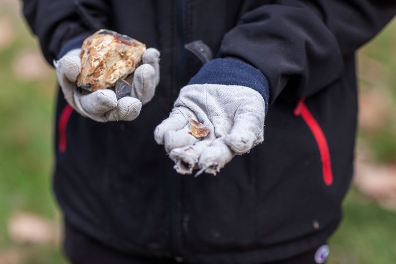 Indigenous culture and science. A student's gloved hands can be seen holding pieces of rock which have been shaped.