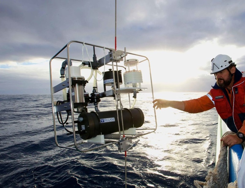 With flat seas, Mark Lewis works with an In situ pump alongside Investigator in the Southern Ocean 