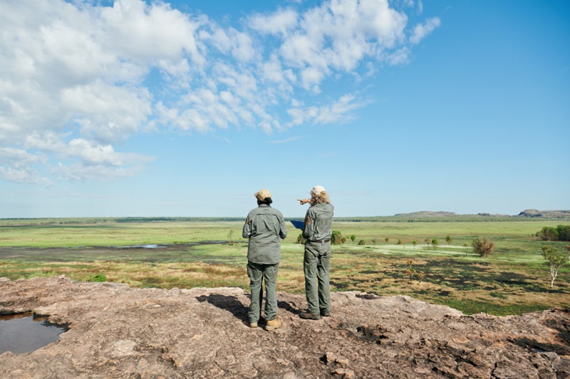 Two people in uniform looking out into the countryside.