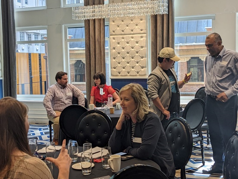 People scattered around a room chatting in small groups.