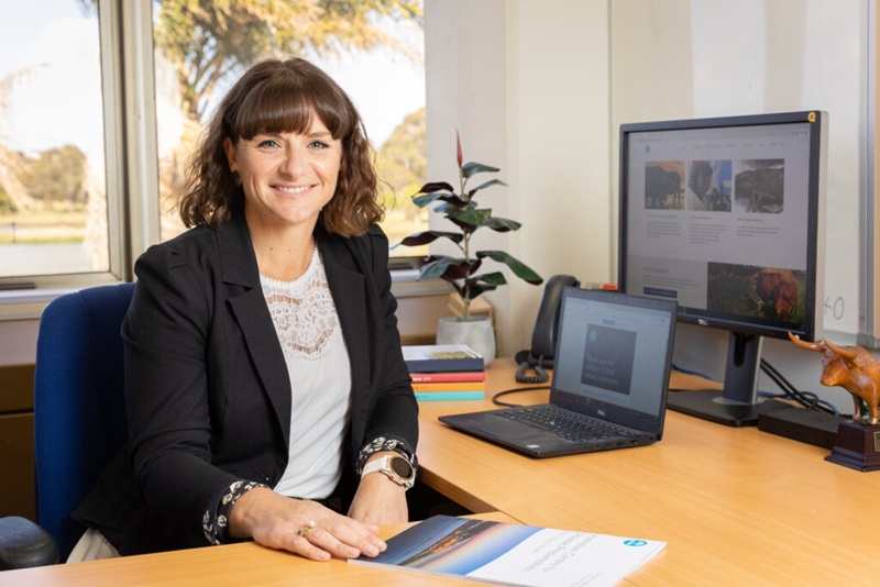 Phoebe Readford sitting at her desk smiling at the camera. 