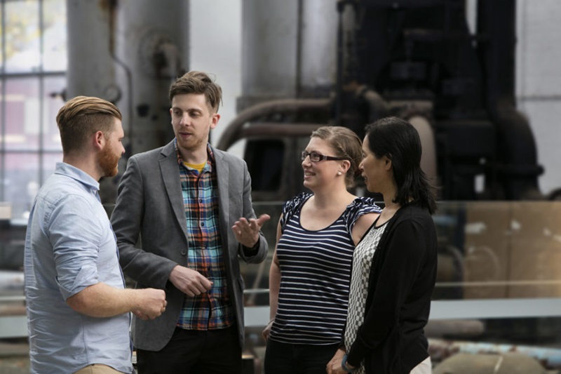 Four people standing having a conversation. 