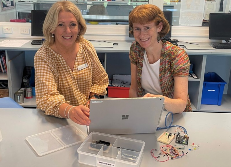 Karen and STEM Professionals in Schools volunteers Sheree sitting at a laptop on a science lab bench. 