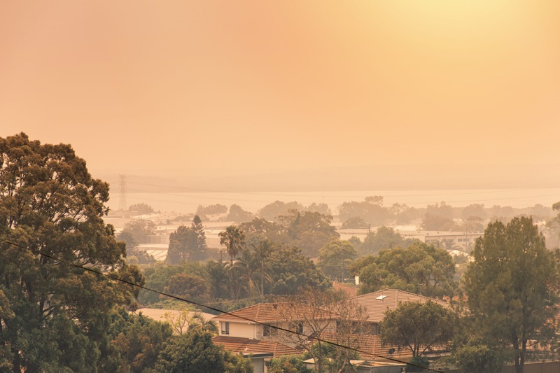 orange-tinged smoke haze from bushfire across Sydney harbour
