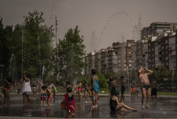 People playing in a fountain in Spain. Climate change weather