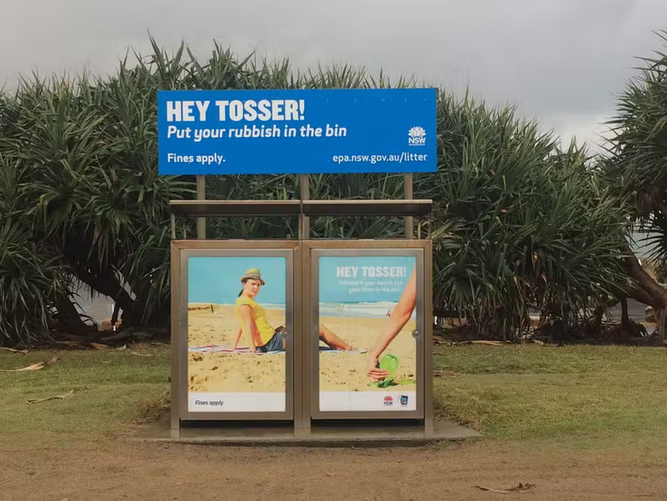 A photo showing recycling bins by a beach.