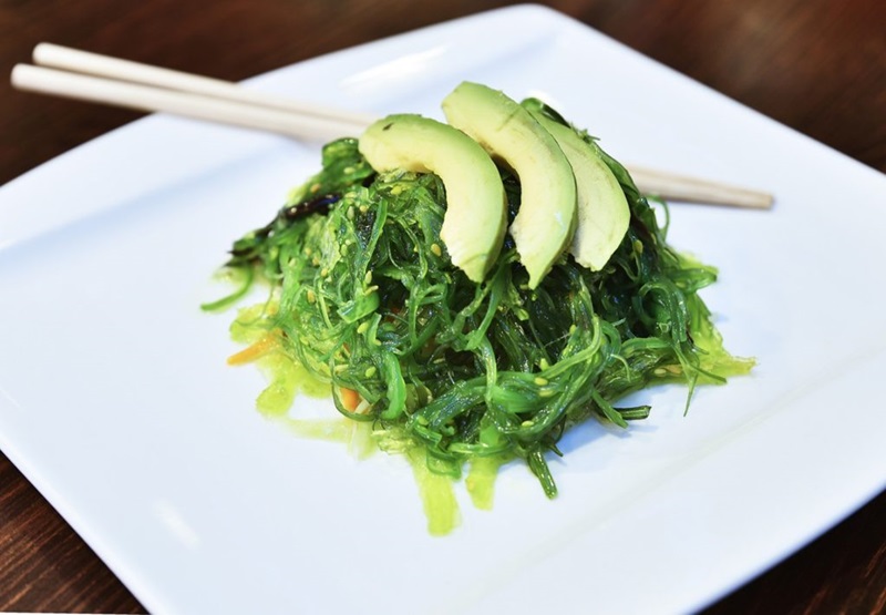 Wakame salad on a plate with sliced avocado on top