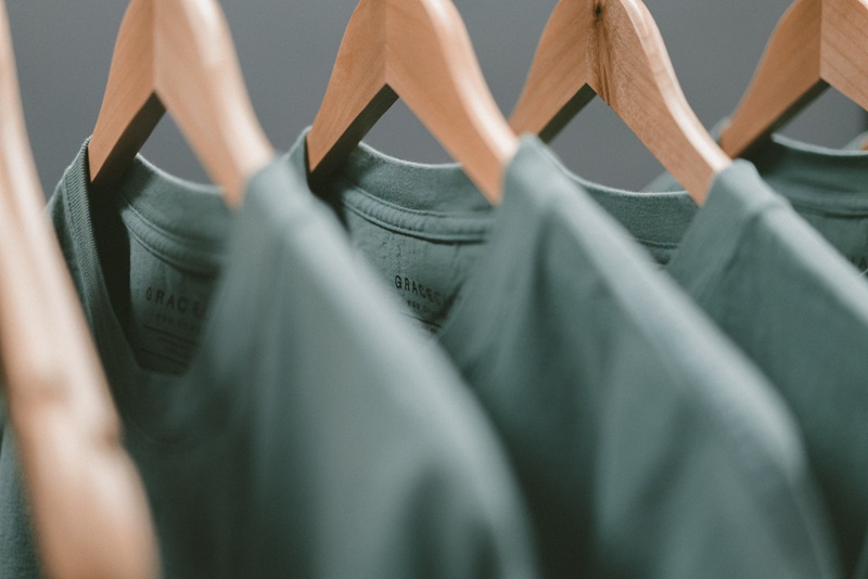 Plae green t-shirts on clothes hangers