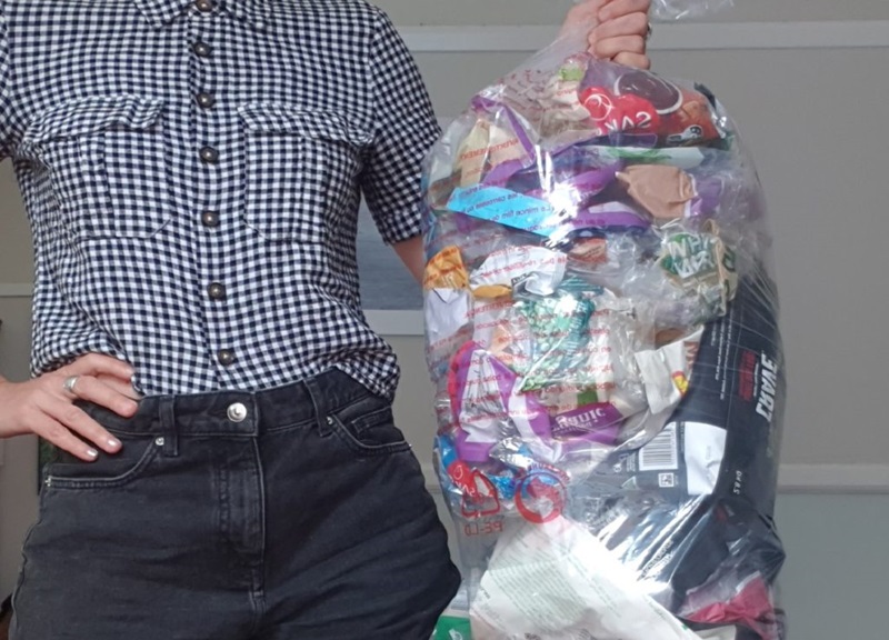 Person holding a bag of soft plastic waste