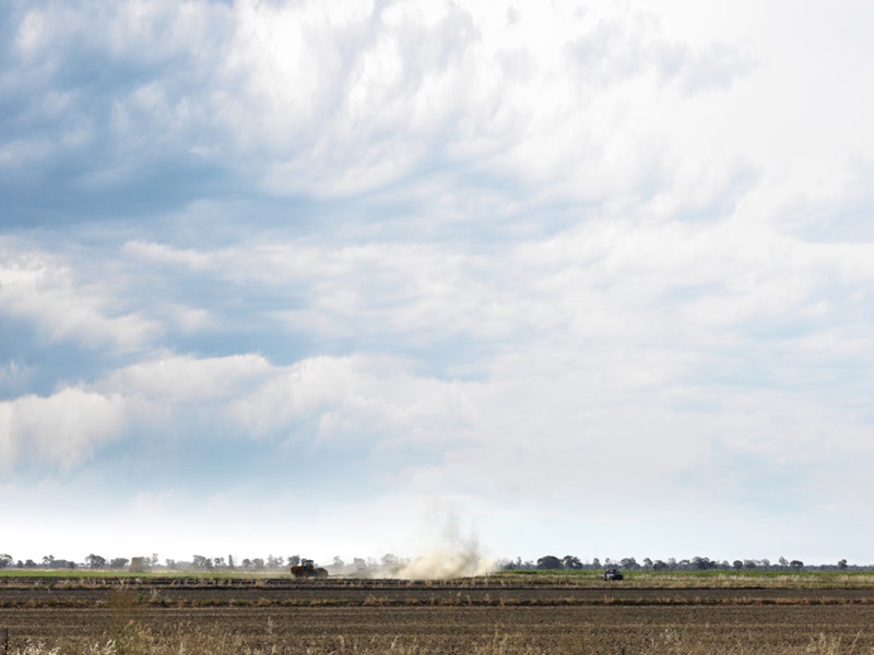 A photo of a tractor moving through an Australian farm
