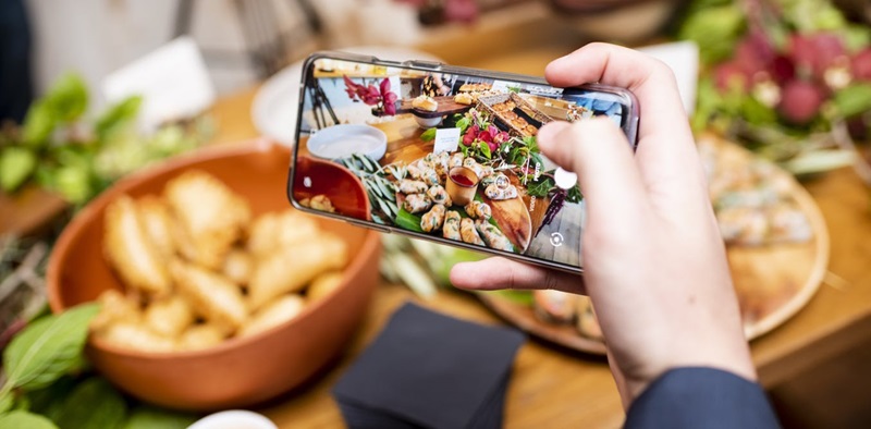 Person taking a photo of food using their phone