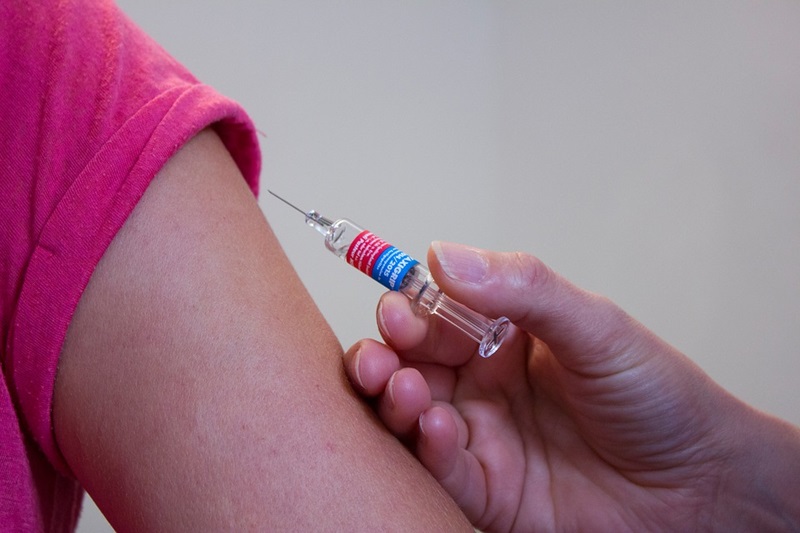 close up arm and vaccine needle