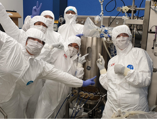 The team in full PPE and posing for the camera. They're working on the COVID-19 vaccine.
