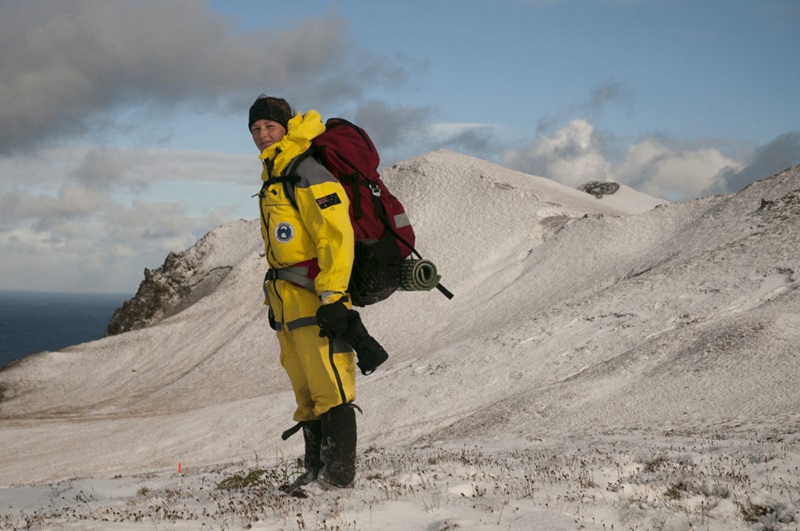 Person in yellow standing in snow
