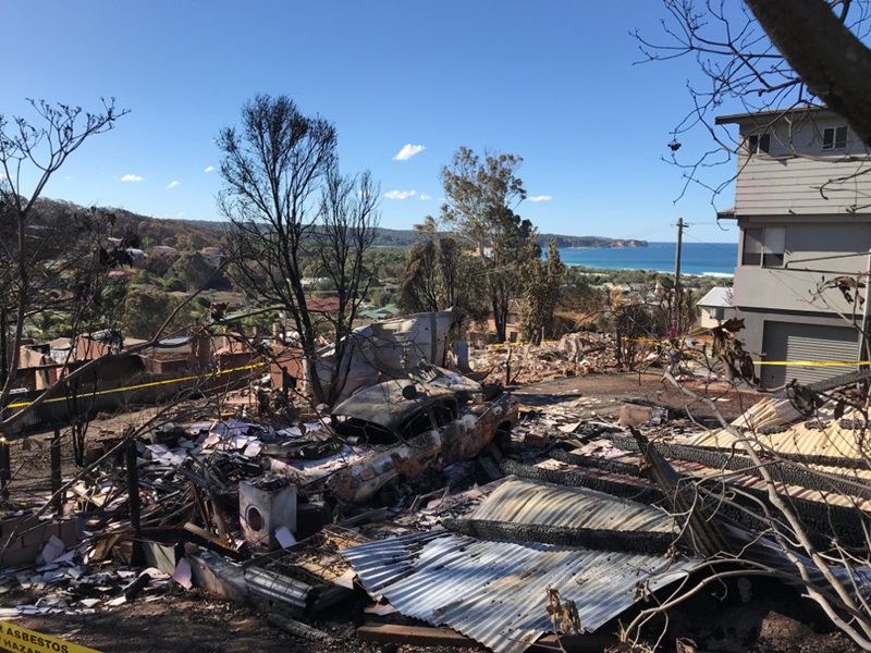 houses destroyed by fier with sea in the background