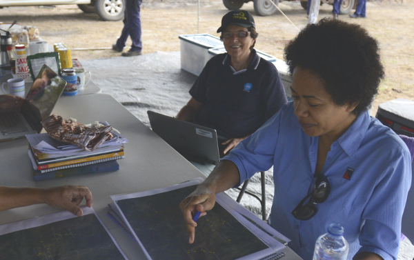 two women at work at a tressel table in the field